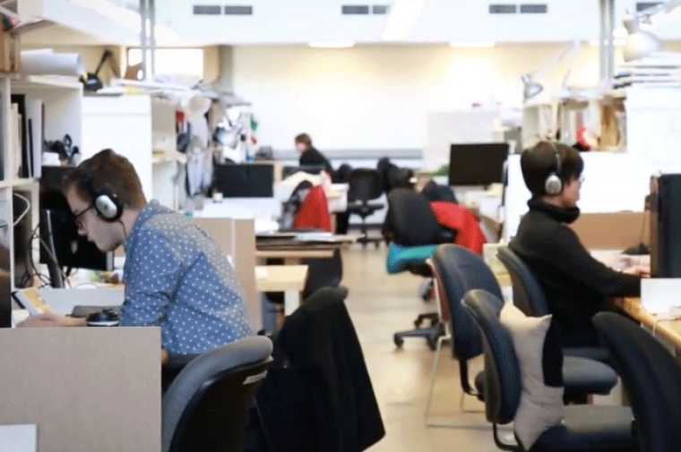 Computer lab with several students working and wearing headphones.