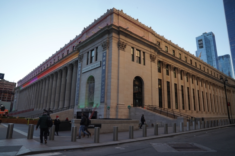 The neoclassical facade of Moynihan Hall seen from the corner at dusk