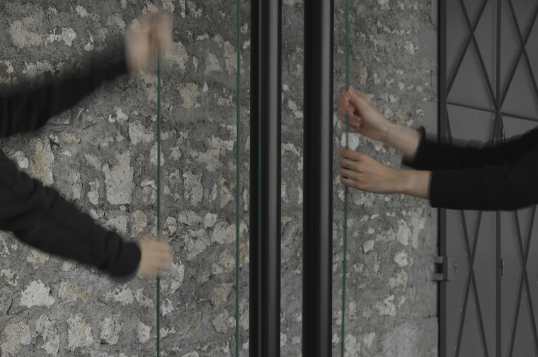 Photograph of two sets of hands in motion activating Sarah Oppenheimer's artwork