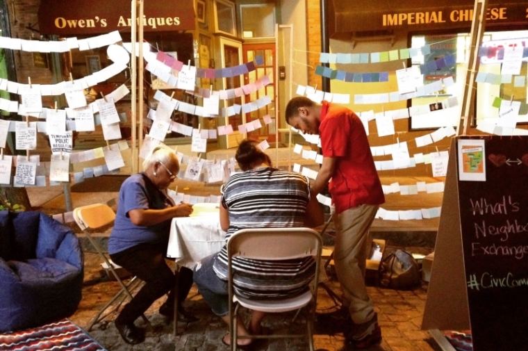 Mt. Airy residents visit the Neighborhood Exchange Box installation during Supper Sessions on Germantown Avenue