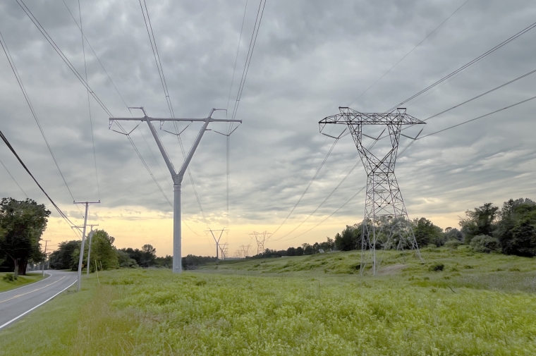 powerlines cascade into a cloudy sky sunset background