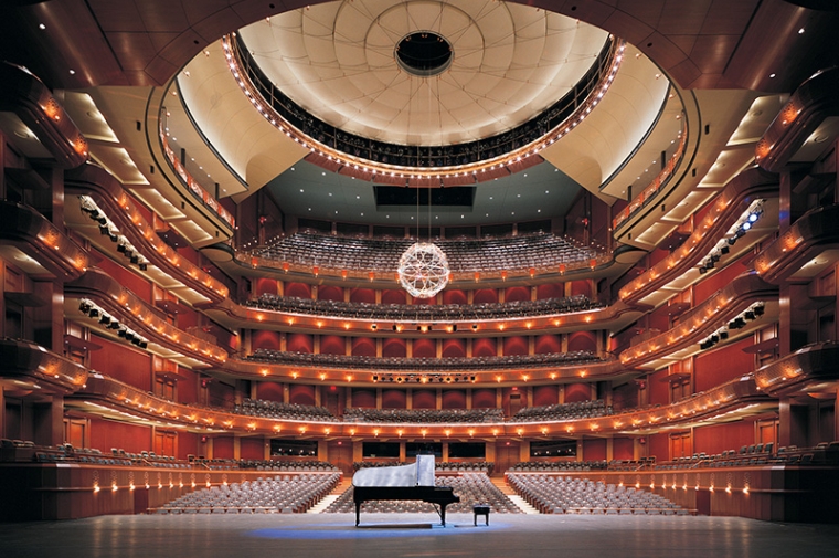 Interior of a modern music hall looking out from the stage with a piano on it