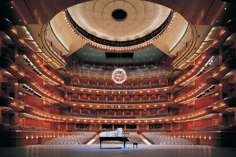 Interior of a modern music hall looking out from the stage with a piano on it
