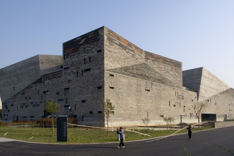Faceted brown monolith with punctured facade seen from street level