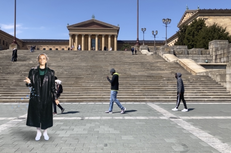 A woman in black attire stands on an outdoor staircase with the museum in the background