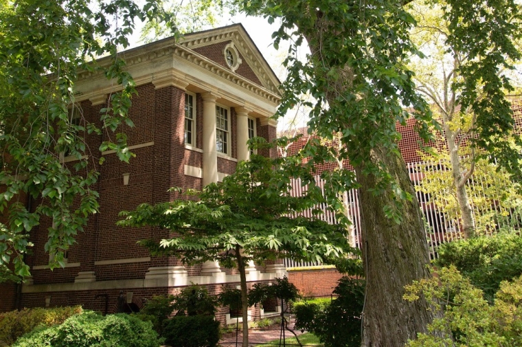 historic brick Greek-inspired pediment with green foliage and bushes