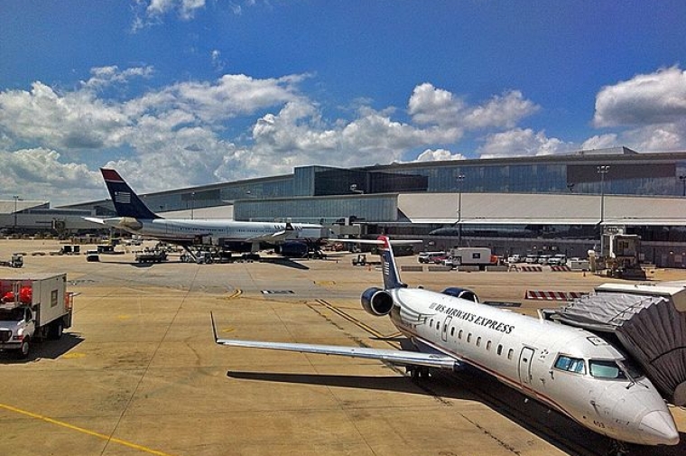 Several airplanes by a terminal at the Philadelphia airport.