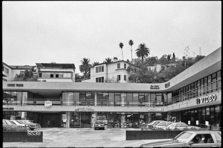 Black and white photo of 3-story drive-up shopping mall