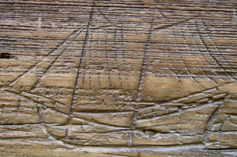 A simple outline of a ship carved in wood