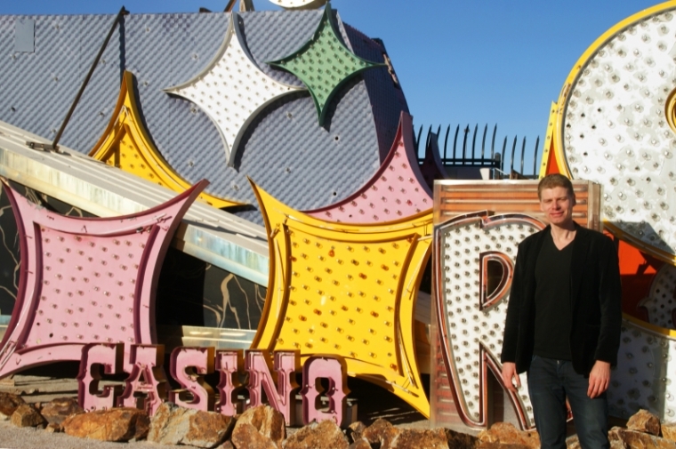 Stefan Al next to neon "Casino" sign