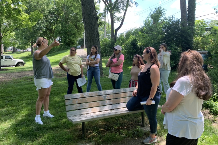 Group of people gathered outside listen to guide
