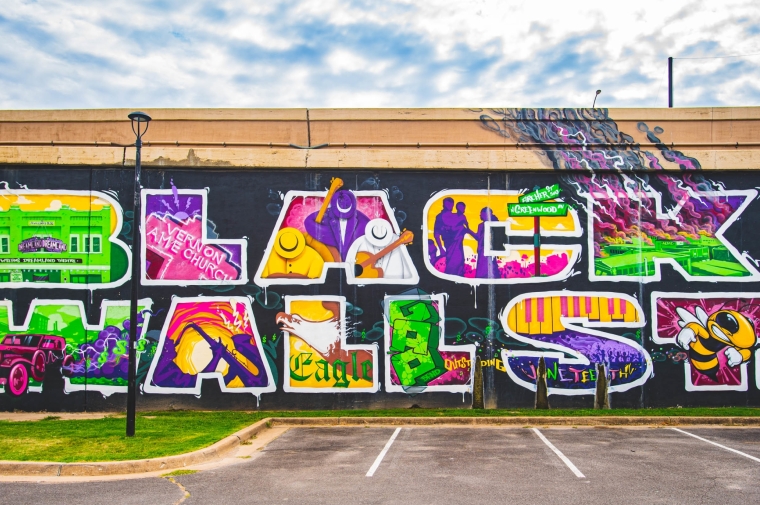 brightly colored exterior mural that reads Black Wall St