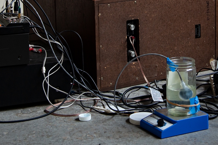 A beaker of liquid connected to an audio speaker