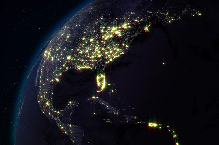 Artist rendering of nighttime view of US from space showing illuminated cities