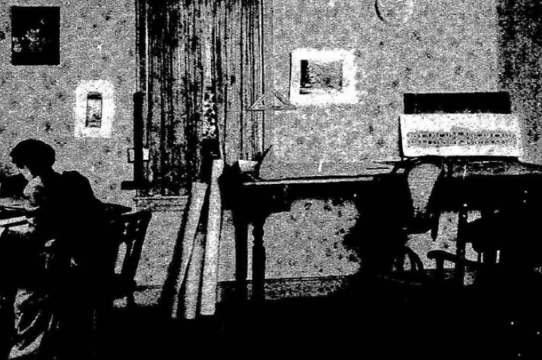 Black and white photo of a woman's silhouette at a drafting table