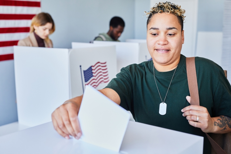 Young woman places ballot in box