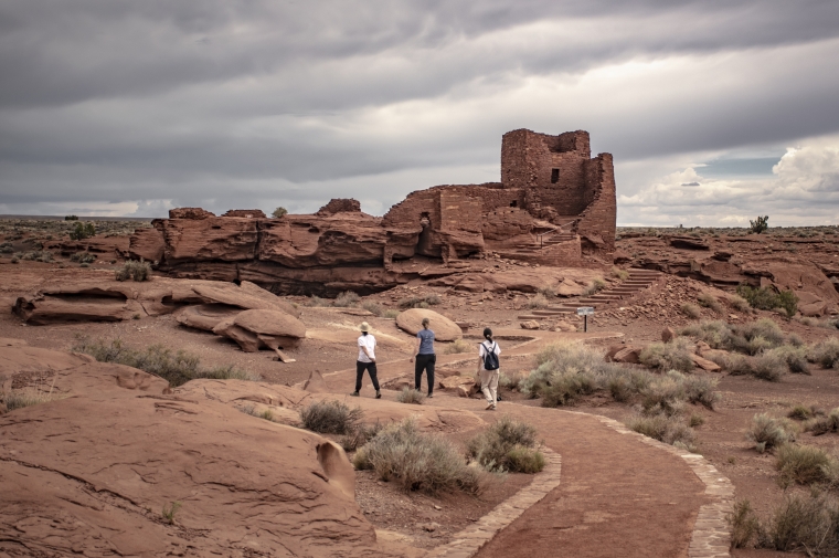 Uninhabited adobe pueblos in vast desert landscape under cloudy sky