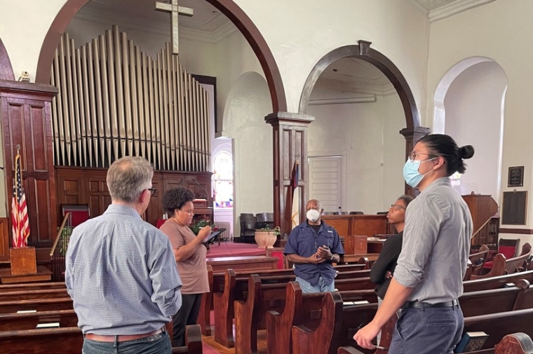 people stand in church sanctuary