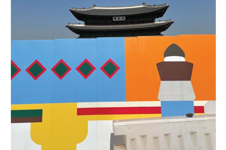 Multi-color painted wall mural with traditional Asian roof behind
