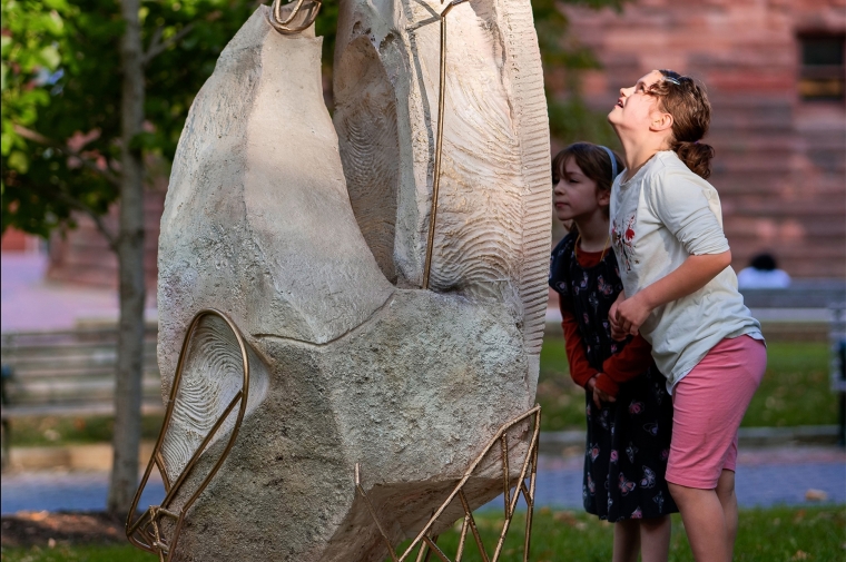 Two children look at a large architectural model