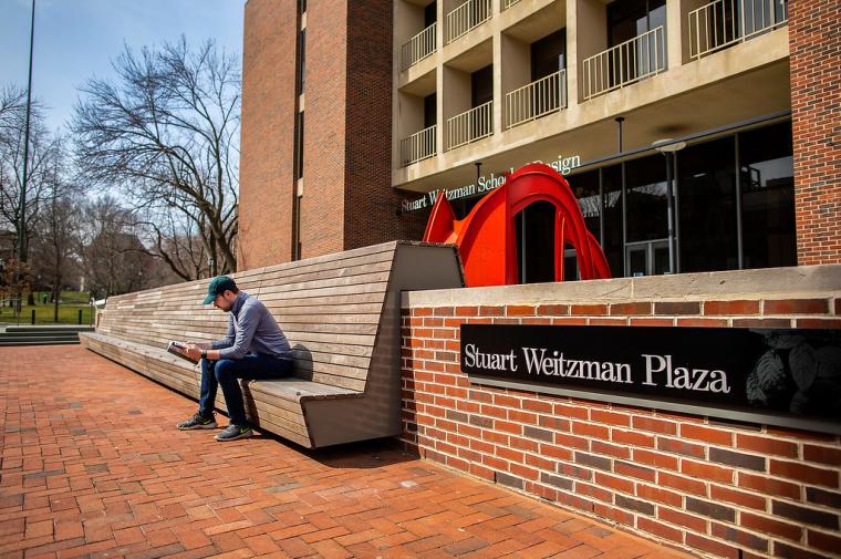 Man sitting on a bench in Stuart Weitzman Plaza