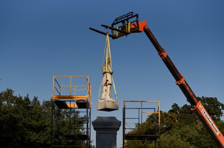 Monument being lifted by crane