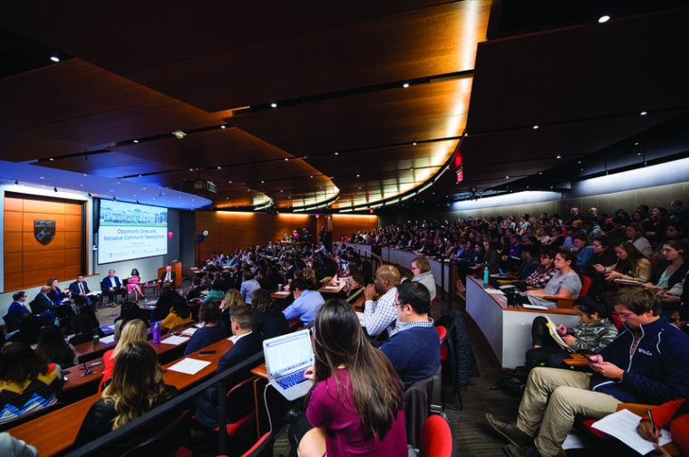 A large group of people watching a conference