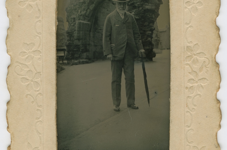 Sepia portrait of old man with cane