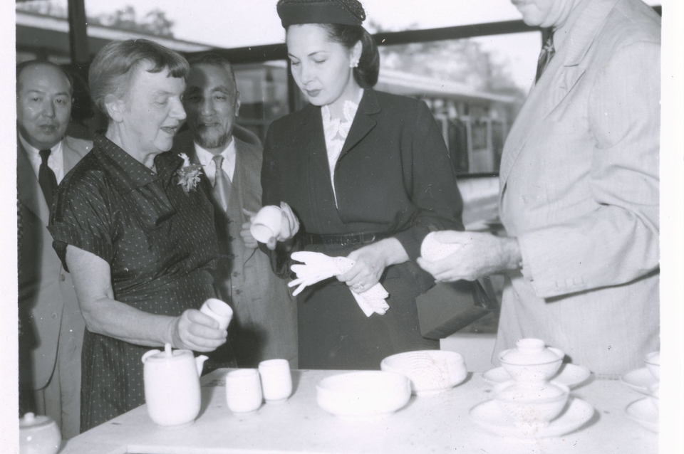 Two women and a man looking at pots