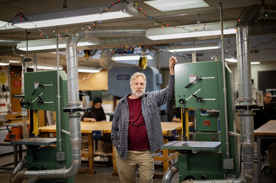 Pierratini poses next to large equipment in the Fab Lab