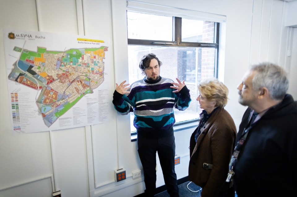 Alex Nelms presenting a map to two faculty members