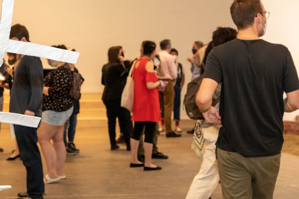 Photograph of a group of people mingling at a gallery