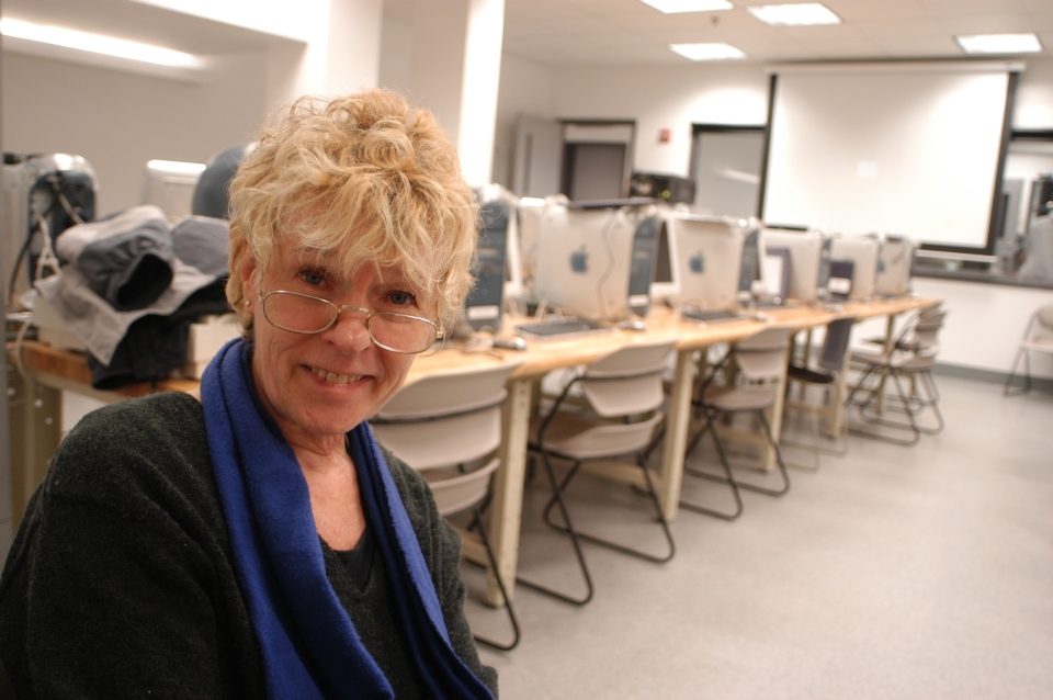 Becky Young seated in a classroom with computers behind her