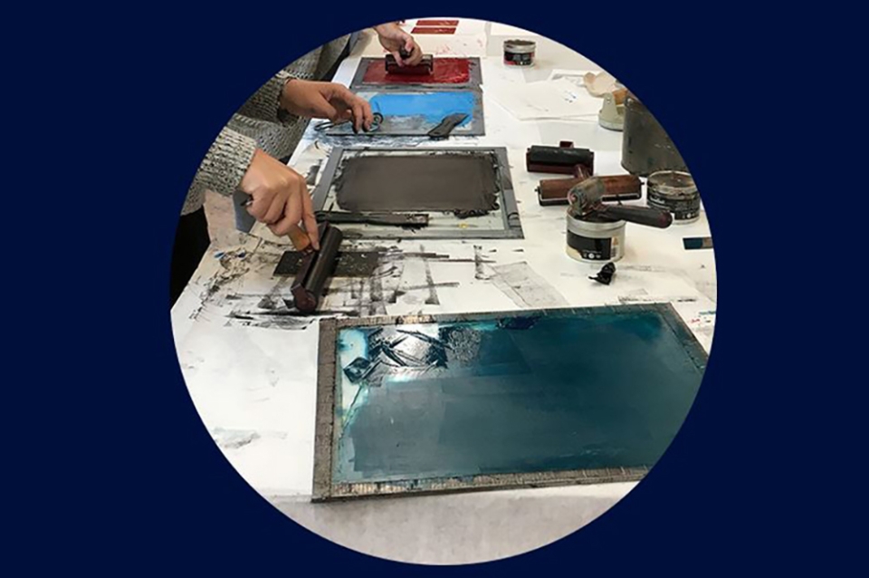 Inked printing screens laid out on a table 