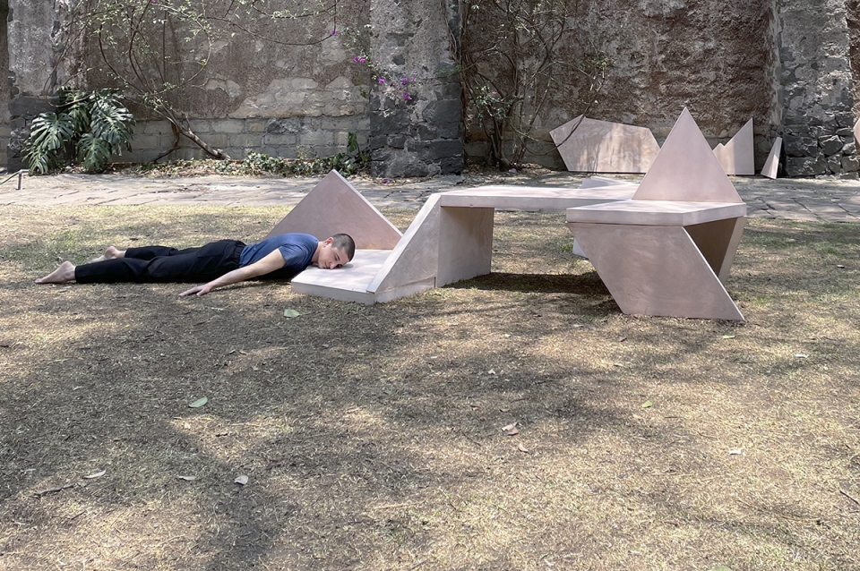 Self portrait of Hall laying face down, resting his head on the edge of his sculpture in a harden