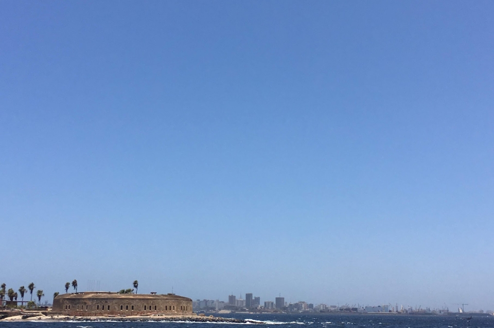 Urban coastline with historic fortress under blue sky