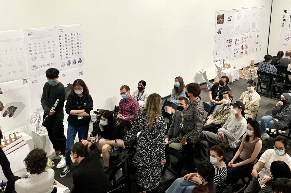 Students gathered in the Plaza Gallery at Meyerson Hall with their work pinned to the walls for review/discussion.