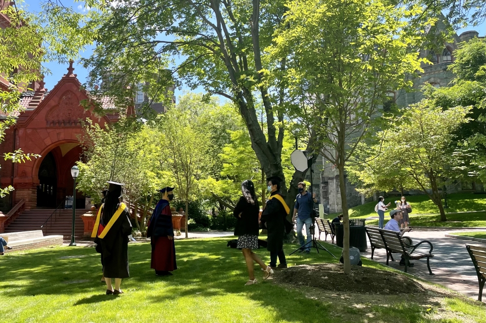 Photo of graduating students in their academic regalia for a photoshoot on campus.