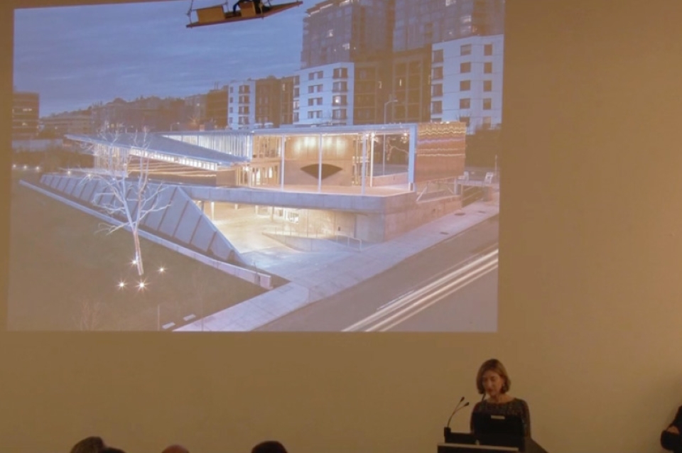 Woman giving presentation with projection in the background