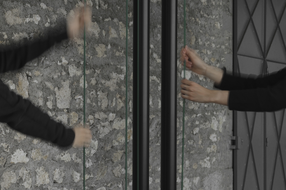 Photograph of two sets of hands in motion activating Sarah Oppenheimer's artwork