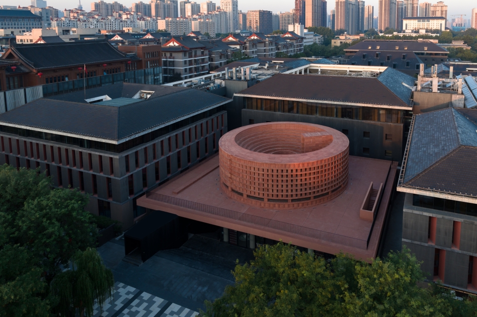 Cylindrical form atop plinth in urban setting