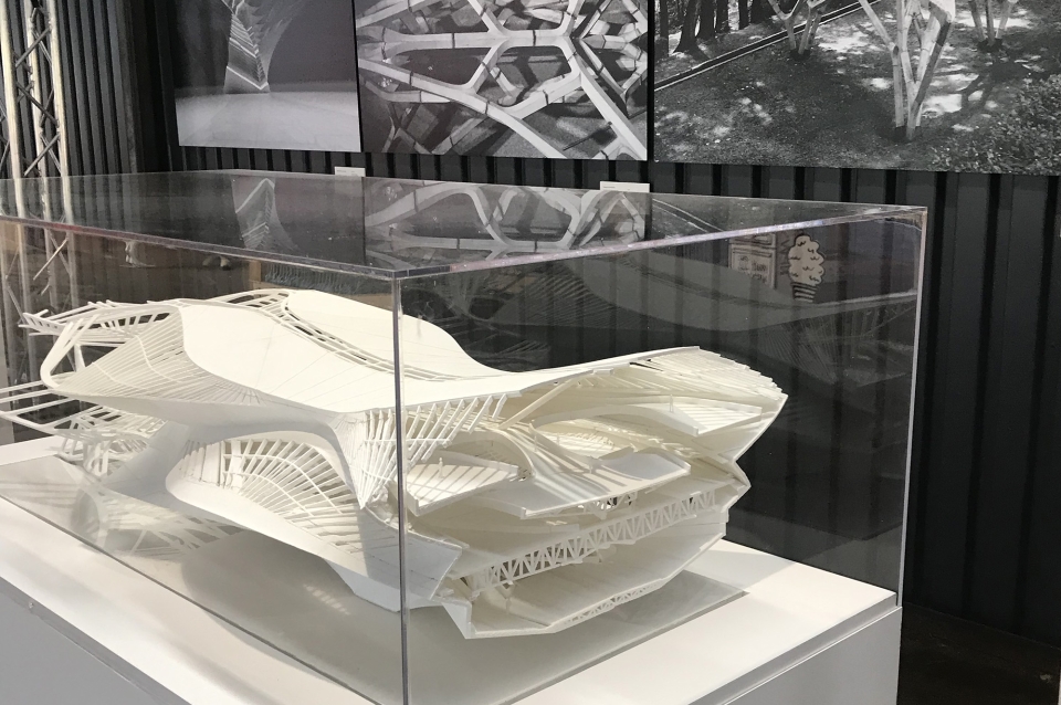 Architectural model in acrylic case with images on the wall behind