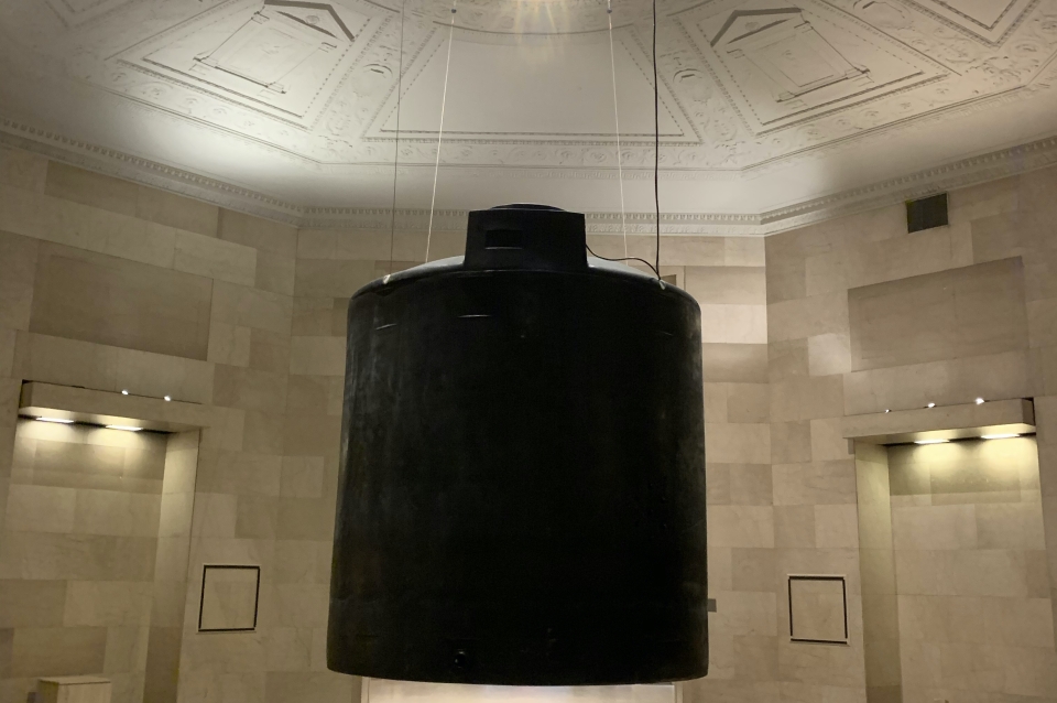 image of artwork installation. large object suspended from ceiling, looking up