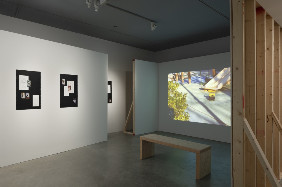 Lumber, plywood, drywall, video, paper, black house paint, reproduced family photos, reproduced publications