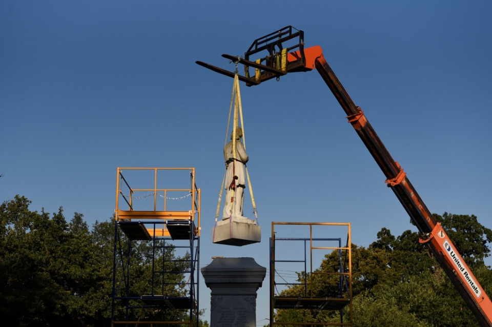Monument being lifted by crane