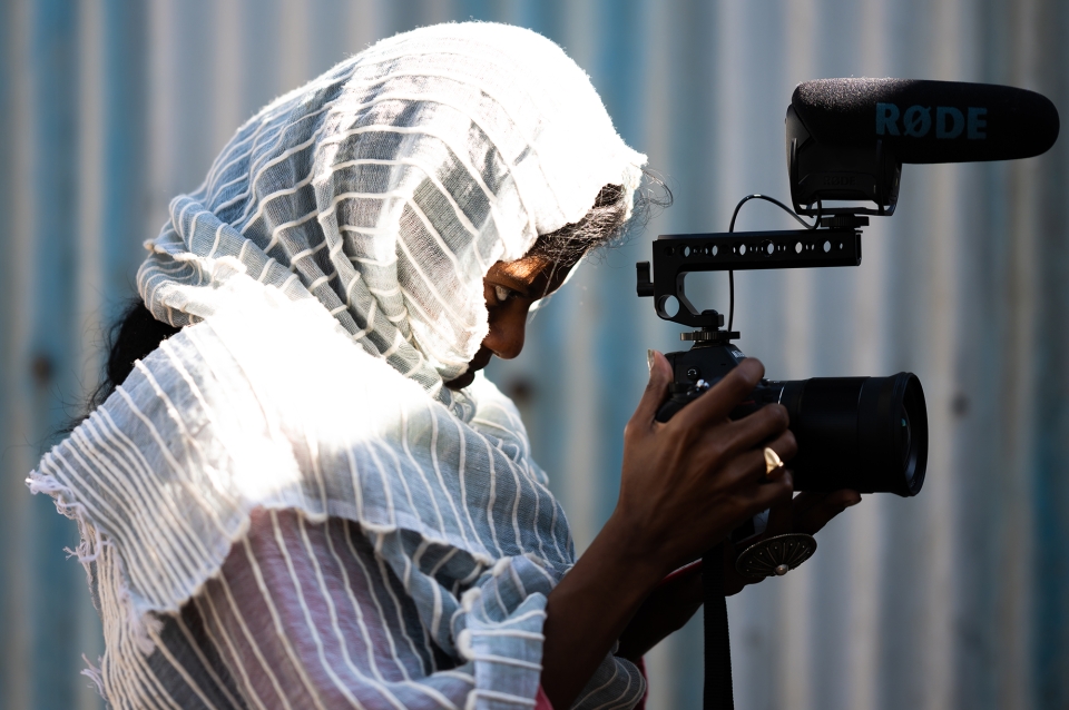 Image of lecturer Sosena Solomon filming with camera in hand.