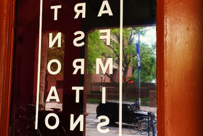 Signs saying "Transformation" with backwards letters in a 3x5 grid pattern