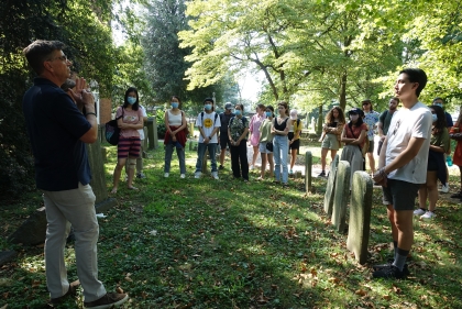 Students gather for lecture in lush green cemetery