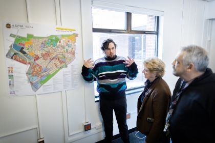 Alex Nelms presenting a map to two faculty members