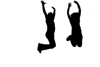 Silhouettes of two people jumping